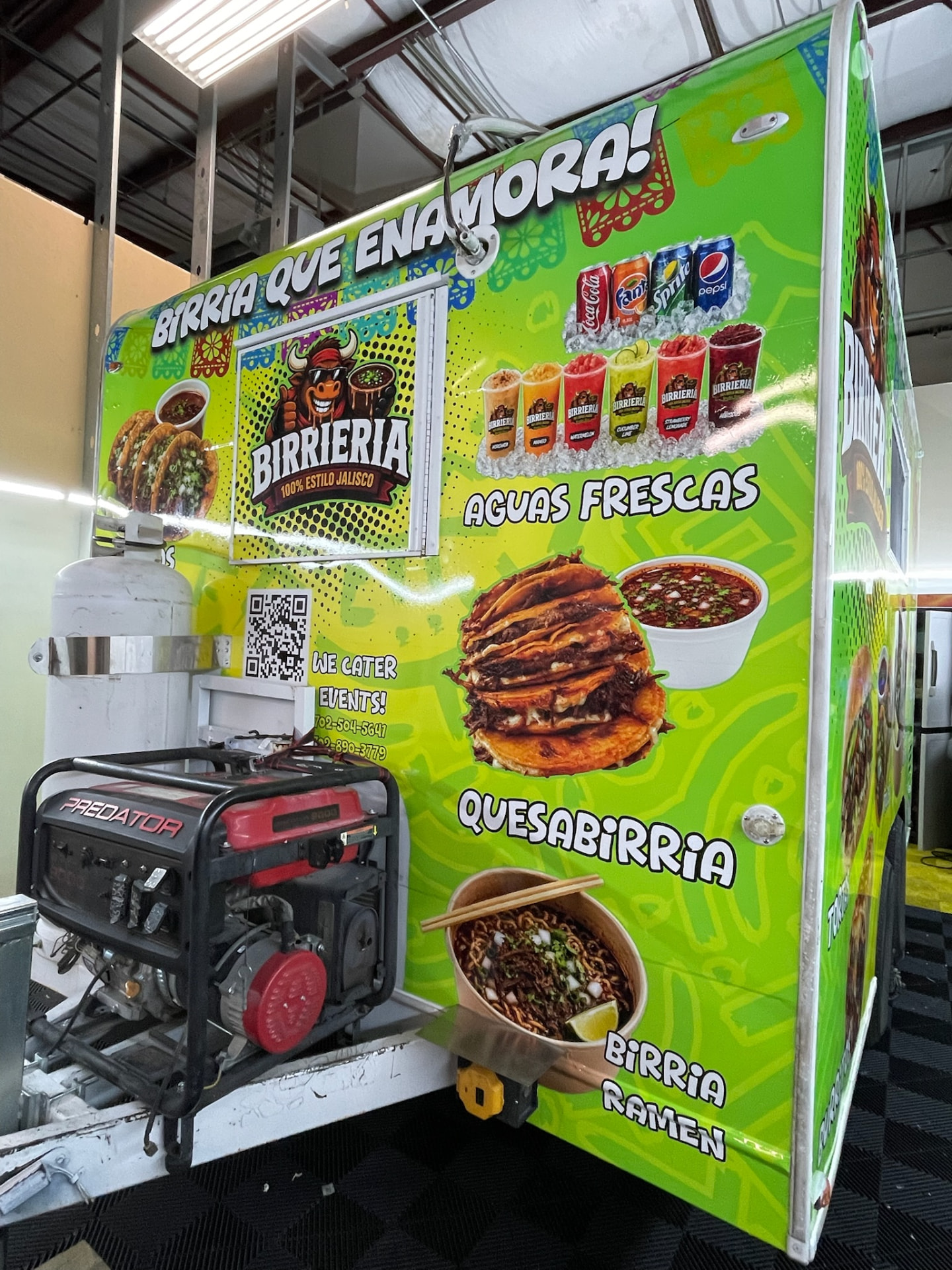 Side of the Birrieria food trailer showing quesabirria, aguas frescas and birria ramen artwork